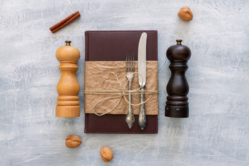 Vintage leather menu with rustic steel or metal silverware with copy space. Top view or above view...