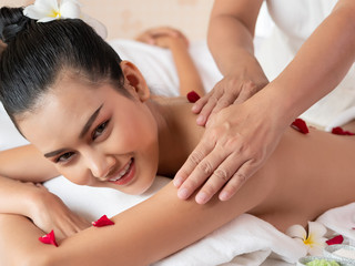 Obraz na płótnie Canvas Beautiful young asian woman lying relaxing and smile on the bed mattresses In the Spa. Thai massage for health. Select focus face women