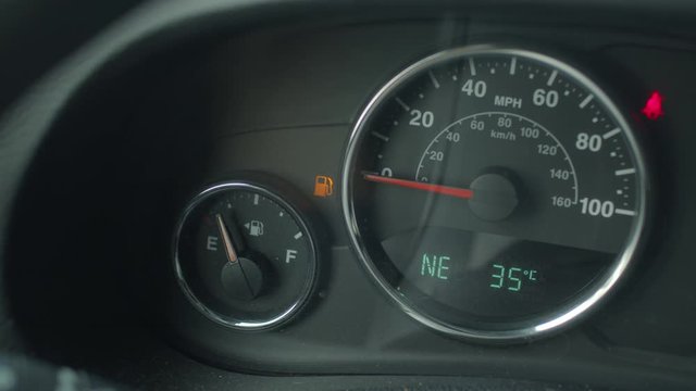Fuel gauge on a dashboard of a car reads as empty.
