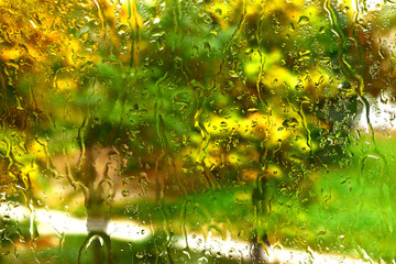 Autumn mood: drops of cold rain spreading across the glass