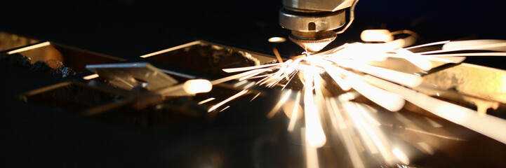Sparks fly out machine head for metal processing laser metal on metallurgical plant background. Manufacturing finished parts for automotive production concept