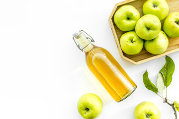 Apple cider in bottle near tray with fruits on white background top view copy space
