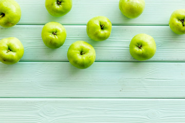 Green apples pattern on green wooden background top view frame copy space