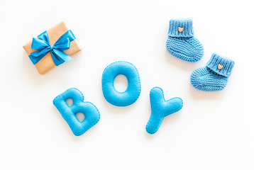 Naklejka premium Children's birthday concept. Word boy near booties and present box on white background top view
