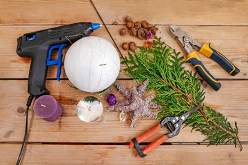 Woman shows how to make Christmas ball with styrofoam sphere and thuja twigs