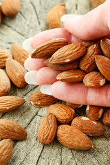 Woman holds almonds in her hands.