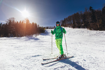 Skier skiing downhill during sunny day in high mountains
