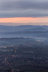 A view of Umbria valley with hills, mist and city lights