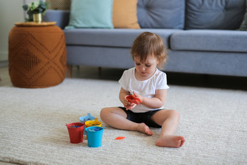 child Toddler plays on the floor near the sofa