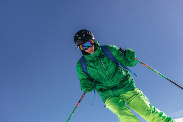 Skier skiing downhill during sunny day in high mountains
