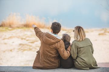 young beautiful family sitting at beach with view lake