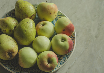 Apples and pears on a ceramic plate. Autumn yogurt organic fruits.