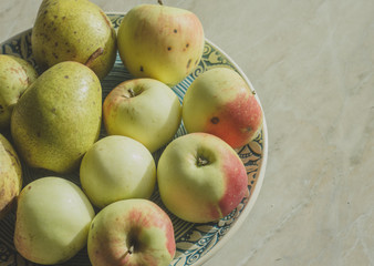 Apples and pears on a ceramic plate. Autumn yogurt organic fruits.