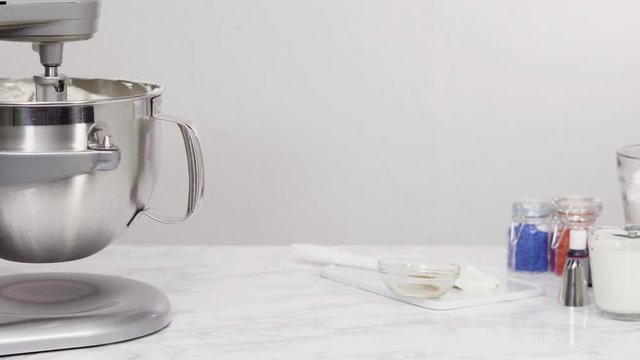 Step by step. Mixing ingredients in standing kitchen mixer to make buttercream frosting.