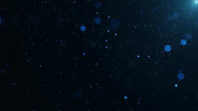 Abstract motion background shining blue particles. Blue floating dust particles with flare on black background. Looped 3D bokeh. 4k Ultra HD loop animation.