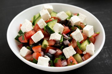 Homemade Shepards salad in a white bowl, side view. Close-up.