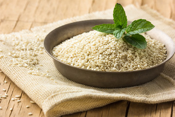 Sesame seeds in a  bowl on wooden table