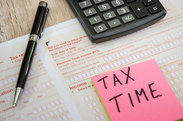 Australian tax return, calculator, pen on a wooden table