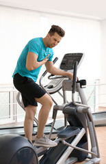 Obraz na płótnie Canvas Young man having heart attack on treadmill in gym