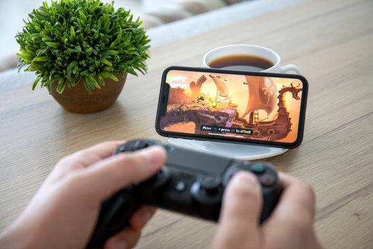 Man Holding Dualshock Play Game Rayman On Screen IPhone 11.