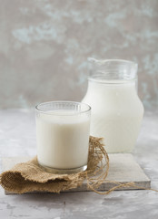coconut milk on white concrete  background, Alternative types of milks. Vegan substitute dairy milk. Milk glass, coconut