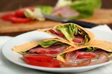 Wrap tortilla sandwich with ham, tomato, lettuce.
