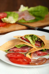 Wrap tortilla sandwich with ham, tomato, lettuce.