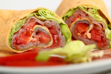 Wrap tortilla sandwich with ham, tomato, lettuce.