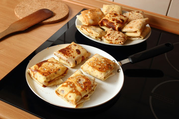 Frying pancakes with fillings. Traditional russian pancakes (blini) with curd. Cheese blintzes.