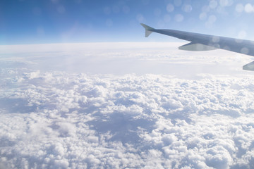 Obraz premium High in the sky, clouds and airplane wing, view from the airplane window