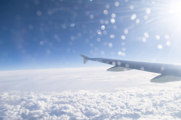 Fototapeta premium High in the sky landscape with clouds and airplane wing, view from the airplane window