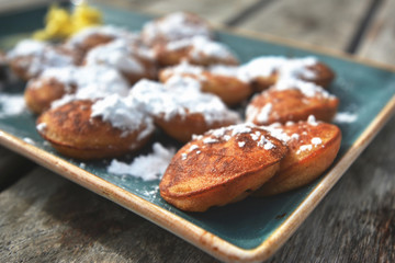 'Poffertjes', a traditional Dutch batter treat dish resembling small, fluffy pancakes, served with powdered sugar and butter