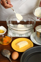 Making Sour Cream Lemon Cake. Adding sour cream into bowl with sugar.