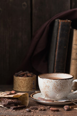 Hot chocolate - winter spicy drink in a brown cup on  wooden background.