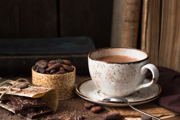 Hot chocolate - winter spicy drink in a brown cup on  wooden background.