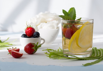 Infused water made from blueberry strawberry and lemon in sparkling mineral water look so freshness and healthy. Mixed fruit mojito on wood table with copy space. Summer refreshing drink concept. Ice 