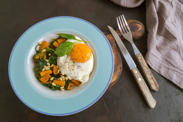 Sunny side up egg with spinach and pumpkin.