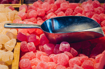 une grosse quantité de bonbons sucrés rouges rose à la fraise et framboise avec une pelle pour servir sur le marché