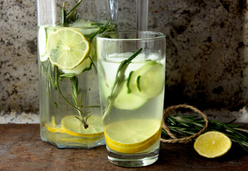 Summer cocktail cucumber lemonade. Refreshing water with cucumber, mint and lemon on grey background. Healthy drink and detox concept. Copy space