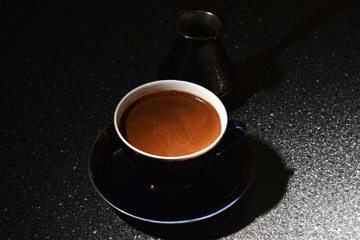A Cup of coffee and a cezva in the dark