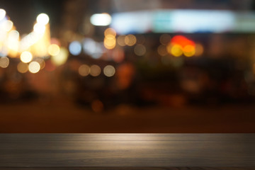Empty dark wooden table in front of abstract blurred bokeh background of restaurant . can be used for display or montage your products.Mock up for space.