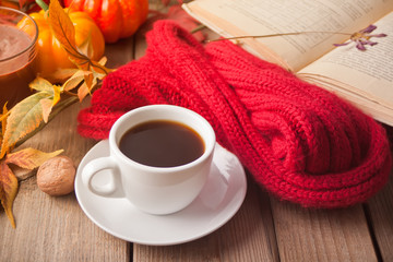 Cup of coffee, autumn leaves, candle, pumpkin, book and blanket. Autumn harvest. Autumn concept.