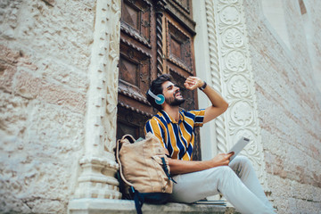 Young handsome tourist men using digital tablet in a city. 