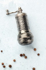 Allspice, Jamaican pepper. Scattered peppercorns with a vintage pepper mill, shot from the top