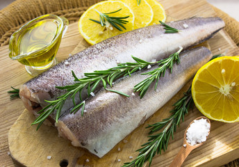 Fresh raw carcass of hake, greenery and lemon. Ingredients for a fish dish