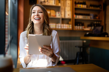 Happy girl working online or studying and learning while using tablet