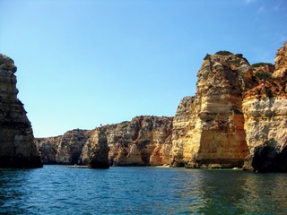 Fototapeta premium Algarve coast with rocky formations. Atlantic coast landscape in Algarve region. Seashore and caves seen from the Atlantic Ocean. Area near Lagos, Portugal, Europe