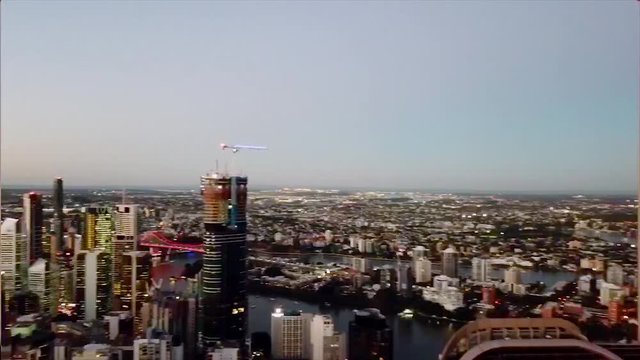 Aerial, pan, drone shot, above skyscrapers, in downtown brisbane, on a clear evening or night, in Brisbane, Queensland, Australia