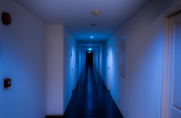 building aisle in blue tone with fire exit sign and alarm