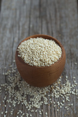 scoop of healthy sesame seeds on sesame seeds background